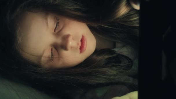 垂直录像 睡前电影 夜用小工具 不停的孩子 睡眠不足的小女孩喜欢深夜在平板电脑上看卡通片 — 图库视频影像