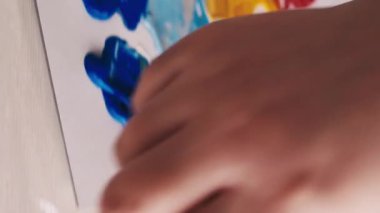 Dikey video. Resim okulunda. Sanat eseri yaratımı. Kadın ressam. Tanımlanamayan bir kadın, renkli spatula resimleriyle tuvalde soyut bir resim oluşturuyor..