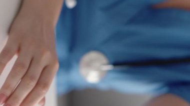 Dikey video. Doktor ücreti. Sağlık sigortası ödemesi. Tanımlanamayan kadın doktorların eli hastadan para alıyor. 100 Amerikan doları nakit para sayıyor..