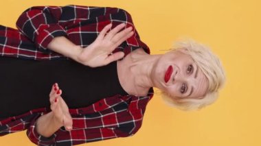 Dikey video. Alkışlayıcı kadın. Sahte tebrikler. Alaycı duygular. Şüpheci orta yaşlı kadın el çırpıyor aptalca sevinç pozları veriyor..