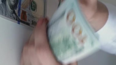Dikey video. Para borcu. Banka kredisi. Finansal hesap. Kadın yöneticinin eli para sayıyor. 100 Amerikan doları..