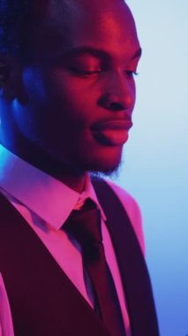 Dikey video. Gezici flört. Sanal arama. Romantik iletişim. Kırmızı mavi neon ışık mutlu gülen adam hava öpücüğü veriyor telefonda kalp hareketi gösteriyor..