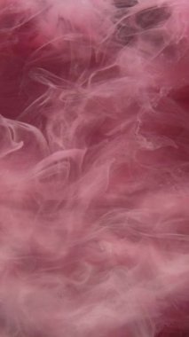 Dikey video. Renkli buhar bulutu. Sis dokusu. Yüzen buhar. Pembe parıldayan sis, ışıldayan toz parçacıkları dalga dalga hareket soyut sanat arka planı.