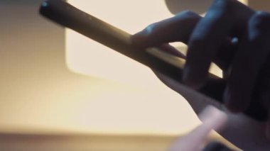 Dikey video. Mobil sohbet bulanık arkaplan. Çevrimiçi iletişim. Gecenin geç saatlerinde telefonda erkek eli mesaj gönderen koyu renk silueti..