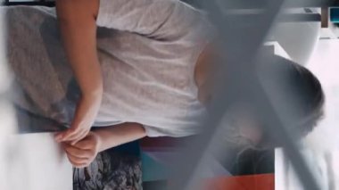 Dikey video. Sanat stüdyosu. Küçük kız. Resim dersi alıyorum. Işık odası içinde çizim yapmak için odaya giren ilham verici bir çocuk..