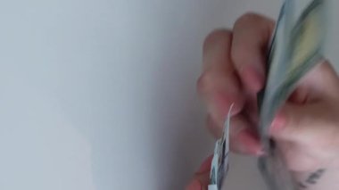 Dikey video. Döviz bürosu. Para politikası. Dünya ekonomisi. Kadın yöneticinin eli kulağında. Avro banknotlu nakit yığınından Amerikan doları sayıyor..