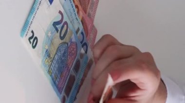 Dikey video. Tasarruf. Finansal kazanç. Maaş ödemesi. Bütçe ekonomisi. Avro nakit para banknotları sayan kadınların yakınlaşması.