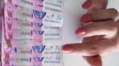 Dikey video. Para geliri. Finansal bütçe. 200 Ukrayna Hryvnia kağıt para yığını kadın eli sayıyor..