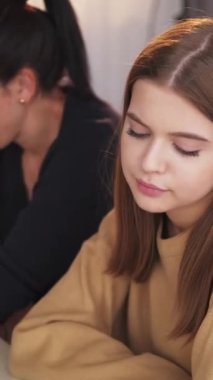 Dikey video. Aile içi kavga. Barışmak. Anne ve genç kız tartıştıktan sonra birbirlerine sarılıyorlar..