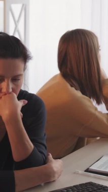 Dikey video. Aile çatışması. Aile içi kavga. Ergen kız annesini gücendirmiş. Oturma masası lambasının iç dekorasyonunu tartışarak birbirini geri çeviriyor..