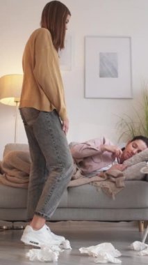 Dikey video. Ev gribi. Ateş acı çekiyor. Kız bakımı. Ateşini ölçen sevecen kız sağlıksız anne gribi belirtileri..