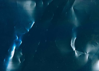 Toz çizikleri üst üste. Kırışık doku. Eski bir film hatası. Mavi beyaz renk düz olmayan yüzey koyu çizim soyut arkaplan.