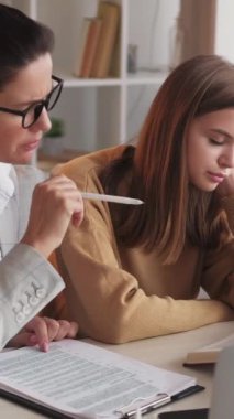 Dikey video. Sıkıcı eğitim. Yetişme dersleri. Uyuyan öğrenci kız, hocasıyla sıkıcı bir dersteyken hafif bir evde oturuyor..