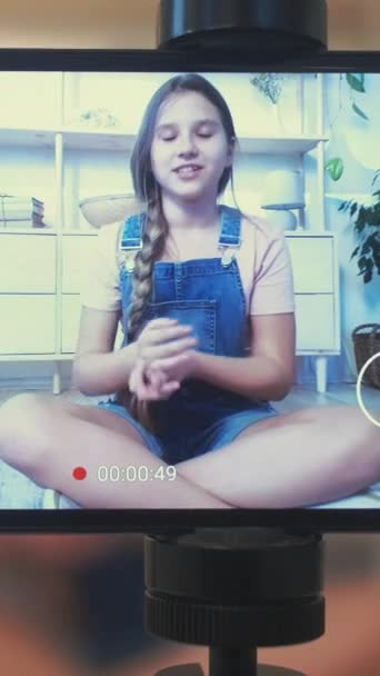 垂直录像 孩子的博客 创建内容 三脚架上的屏幕 带着充满自信的女孩在家里用相机为博客录音 — 图库视频影像