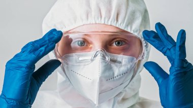 Çevre bilimcisi. Enfeksiyon felaketi. Koruyucu tıbbi ekipman uzmanı kadın ekoloji uzmanı koruyucu gözlükler maske eldivenler gri arka planda izole edilmiş..