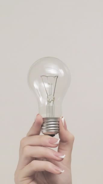 垂直录像 创意灯 想法灯泡 女子手显示一组2个手势 显示在灰色自由空间背景下隔离的电气设备 — 图库视频影像
