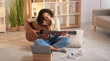 Gitarist. - Kız öğrenci. Mesafe kursları. İlham verici kadın gitarist evde online ders çalışan telli enstrüman akorları çalıyor..