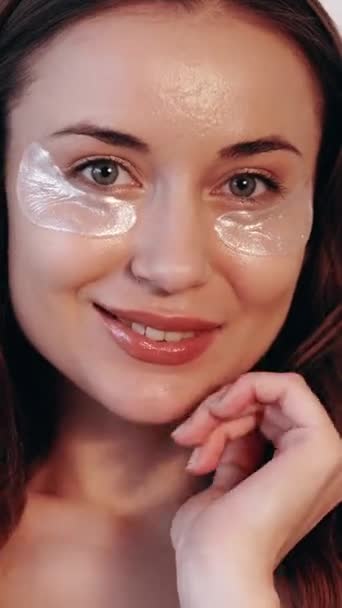 垂直ビデオ 目の皮膚の下 化粧品のパッチ しわを減らす 気をつけて 幸せな女性は 結果に満足スキンケアハイドロゲルコラーゲンパッドで顔を回復 — ストック動画