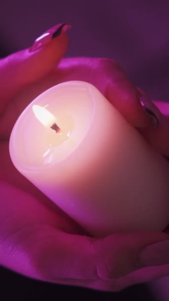 垂直ビデオ ろうそくの香り アロマセラピー いい雰囲気だ 女性の手の閉鎖燃焼大豆ワックスライト炎で活気のあるピンクのネオン — ストック動画