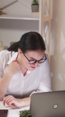 Dikey video. Sanal arama. Çevrimiçi toplantı. İnternet konferansı. Kendine güveni tam, zeki bir iş kadını modern ofis işyerinde laptopla iş hakkında konuşuyor..