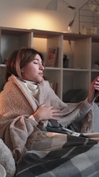 영상입니다 온라인 건강하지 미소짓는 여자가 스마트폰으로 대화하는 거실에 앉아서 — 비디오
