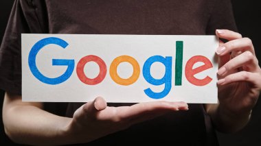 Kharkiv, Ukrayna - 12 Mayıs 2020: Google logosu. Web arama motoru. Çevrimiçi reklamcılık. Kadın elleri yazılım tabelasını karanlık boşlukta tutuyor.