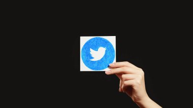 Kharkiv, Ukrayna - 12 Mayıs 2020: Twitter simgesi. Sosyal medya. Ağı izle. Uygulama logosunu gösteren kadın eli koyu siyah boş arkaplanda izole edilmiş.