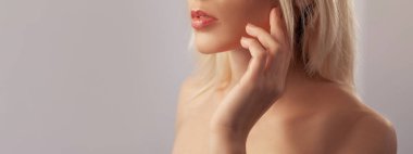 Dudak makyajı. Pompa parlatıcısı. Dikkat balsam. Ruj sürmüş kıvrımlı ağzıyla tanınmayan bir kadın mükemmel bir yüze dokunuyor bej arka planda izole edilmiş boş bir alana..