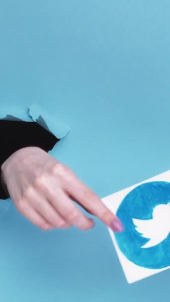 Kharkiv Ukraine June 2020 Vertical Video Twitter图标 女性订户手交突破纸孔接受社交媒体应用标识蓝色撕破空白处背景 — 图库视频影像
