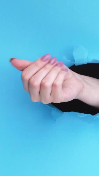 垂直录像 钱的姿势工资标志 女性的手要求在蓝色撕破的纸墙底座上有一个有空隙的突破口 以获得现金 — 图库视频影像