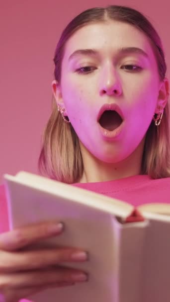 垂直ビデオ 本の祭りだ 文学広告 教育の驚き 驚きの女性ショッキングストーリー情報すごい感情上のピンクの背景 — ストック動画