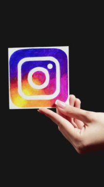Kharkiv, Ukrayna - 12 Mayıs 2020: Dikey video. Instagram simgesi. Sosyal ağı takip et. Siyah boş arkaplanda izole edilmiş kadın el paylaşım uygulaması işareti.