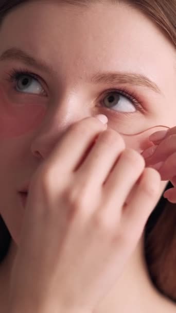 垂直ビデオ 回復パッチだ 眼の下のケア アンチエイジング治療 顔の化粧品 きれいな女性は手で皮膚に直面するハイドロゲルスキンケアパッドを適用します — ストック動画