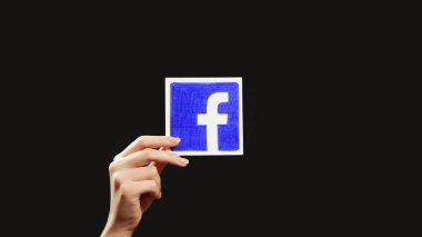 Kharkiv, Ukrayna - 12 Mayıs 2020: Facebook logosu. Sosyal ağ. Dijital pazarlama. Uygulama simgesini gösteren kadın eli koyu siyah kopyalama arkaplanında izole edilmiş.