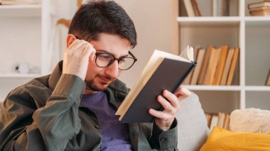 Kitap arsası. Sert edebiyat. Gözlerim iyi görmüyor. Gözlüklü gergin adam evdeki kanepede kafa karıştırıcı kağıt romanlarla boğuşuyor..