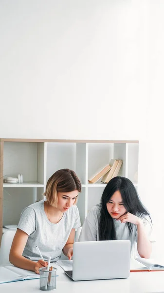 一起学习 在家工作的合作 两个女孩坐在办公桌前 带着笔记本电脑学习完成任务 准备在家里的空余地方写试卷 — 图库照片