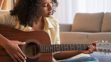 Müzik alıştırması. Gitar keyfi. Dişi oyuncu. Konsantre kadın gitarist sınıftaki telli akustik enstrümanla şarkı söylüyor..