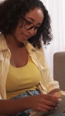 Dikey video. Yurt içi okumalar. Boş zamanlarımda kitap okurum. Düşünceli kız öğrenci hafta sonunun keyfini çıkarıyor..