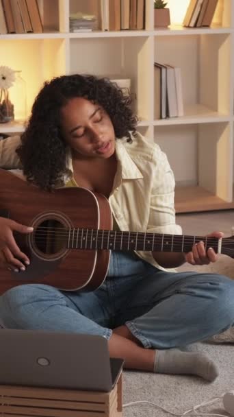 垂直ビデオ ギター奏者 音楽教育 創造的な趣味 才能ある女性ギタリスト歌演奏弦楽器の家の部屋に座って — ストック動画