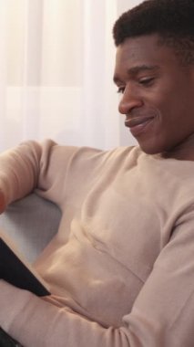 Dikey video. Kitap dinlendiriyor. Boş vakitleri değerlendiriyorum. Ev içi rahatlık. Huzurlu, neşeli bir adam edebiyat romanı en çok satanlar kitabıyla rahat hafta sonunun keyfini çıkarıyor..