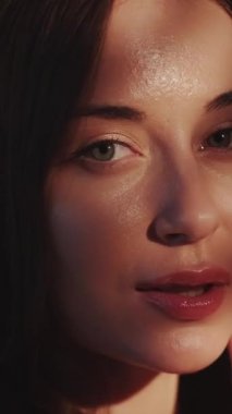 Dikey video. Yüz derisi. Model pozu. Kadın zarafeti. Şehvetli, nazik, güzel bayan, güneş ışığının tadını çıkarıyor. Gölge eller, kusursuz cilde dokunuyor..