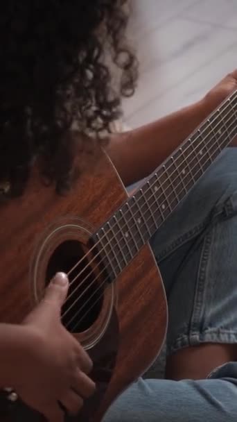 垂直ビデオ ギター演奏 アコースティック音楽 ホームレジャー 居心地の良い床の上に弦楽器を練習する女性ギタリストの閉鎖 — ストック動画