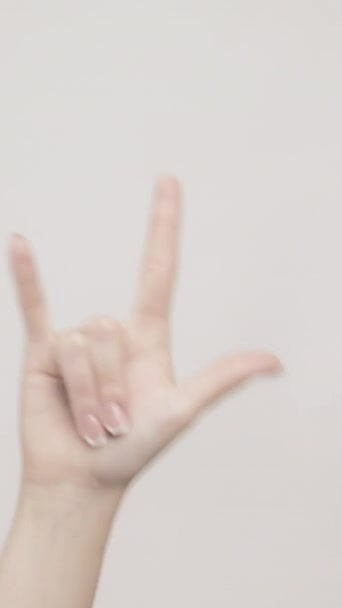 垂直录像 岩石标志 朋克的手势在灰色的自由空间背景下 女性的手显示出孤立的角符号 — 图库视频影像