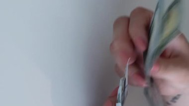 Dikey video. Döviz bürosu. Para politikası. Dünya ekonomisi. Kadın yöneticinin eli kulağında. Avro banknotlu nakit yığınından Amerikan doları sayıyor..