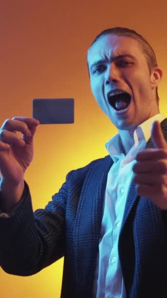 垂直ビデオ 銀行サービス デジタルマネー 電子取引だ 満足幸せなビジネス男推薦クレジットカードとともに親指アップジェスチャーでオレンジ — ストック動画