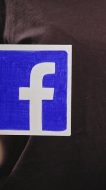 Kharkiv, Ukrayna - 12 Mayıs 2020: Dikey video. Facebook gibi. Sosyal medyayı takip et. Kadın elleri web sitesi simgesini tutuyor. Koyu renk tasarım işareti..