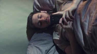 Dikey video. Telefon gecesi. İnternette uykusuzluk. Sanal iletişimin sonlarına doğru. Karanlık yatak odasında elektronik aletlerle internette sörf yapan sıkıcı depresif adam..