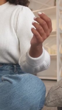 Dikey video. Yoga meditasyonu. Nefes egzersizi. Tanımlanamayan bir kadın evde dinlenip evde lotus pozu veriyor..