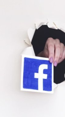 Kharkiv, Ukrayna - Haziran 04, 2020: Dikey video. Sosyal medya logosu. Kadın el paylaşımı Facebook TikTok Instagram Twitter sitesi simgeleri beyaz döngü üzerindeki çığır açan kağıt deliğinden.