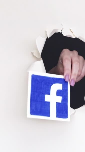 ハリコフ ウクライナ 2020年6月4日 垂直ビデオ ソーシャルメディアのロゴ 女性の手を共有するFacebook Tiktok Instagramホワイトループ上の画期的な紙の穴からのTwitterサイトのアイコン — ストック動画